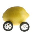 Lemon on car wheels to depict lemon law concept