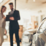 Woman talking to car salesman at dealership