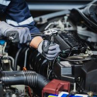 Professional mechanic working on the engine of the car in the garage. Car repair service.